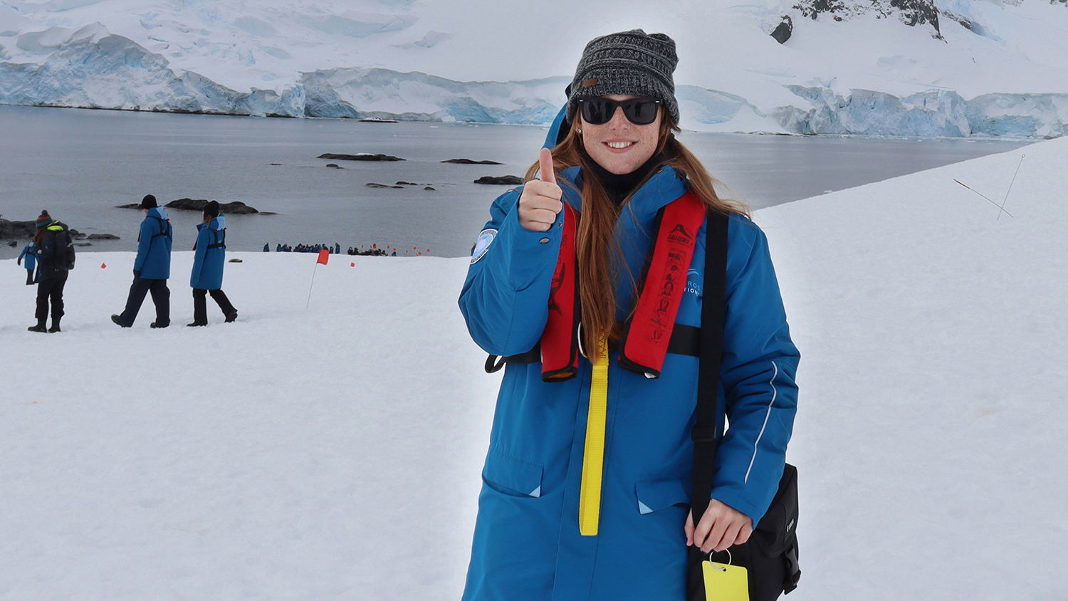 Student giving thumbs up in antarctic landscape