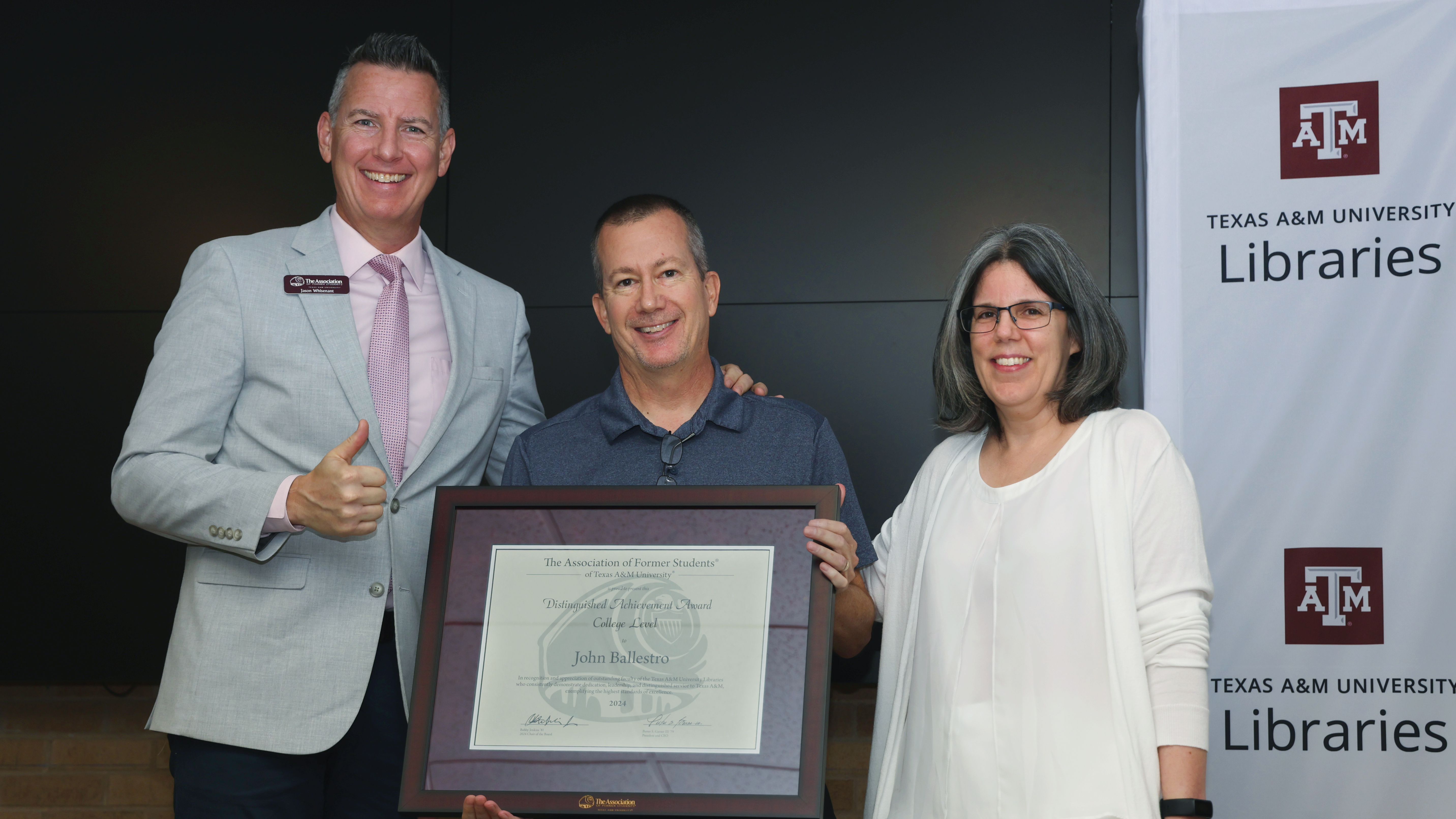 John Ballestro holding his award, standing next to Jason Whisenant and Susie Goodwin