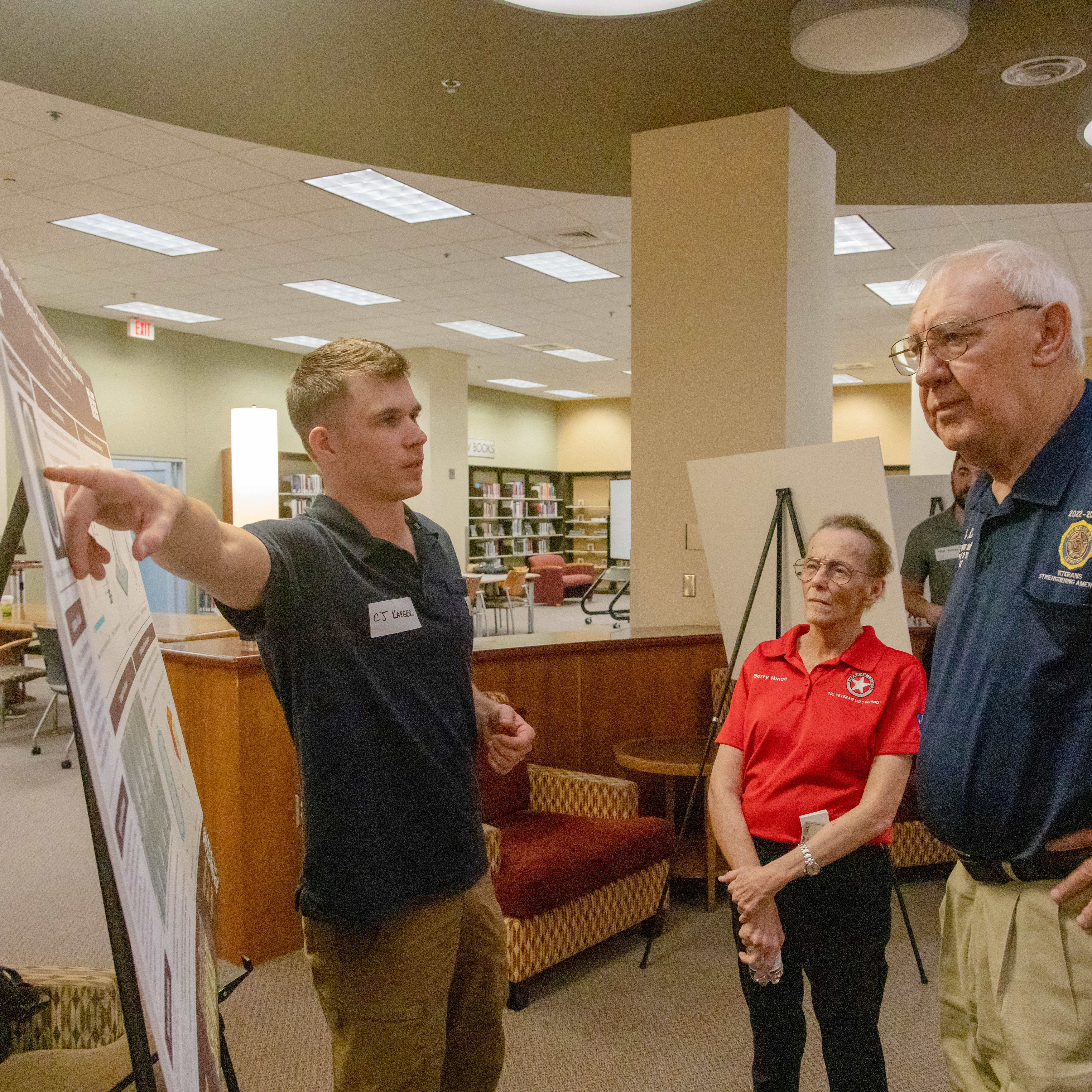 Veteran discussing his research with two Showcase visitors